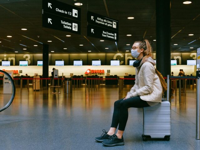 Photo of woman in mask sitting in airport