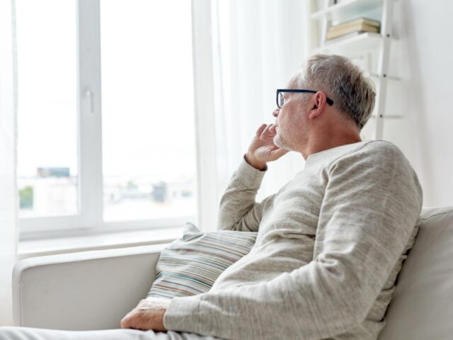 Photo of man looking out of window