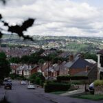 a view of a street in a town with a landscape behind