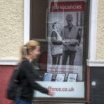 A woman walks past a Job Centre
