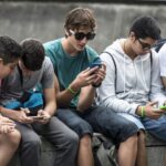 a row of teenage boys looking at phones