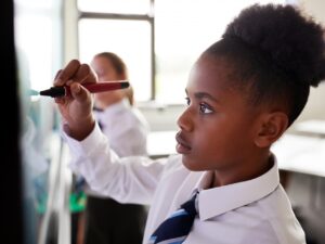 a girl in school uniform at a whiteboard